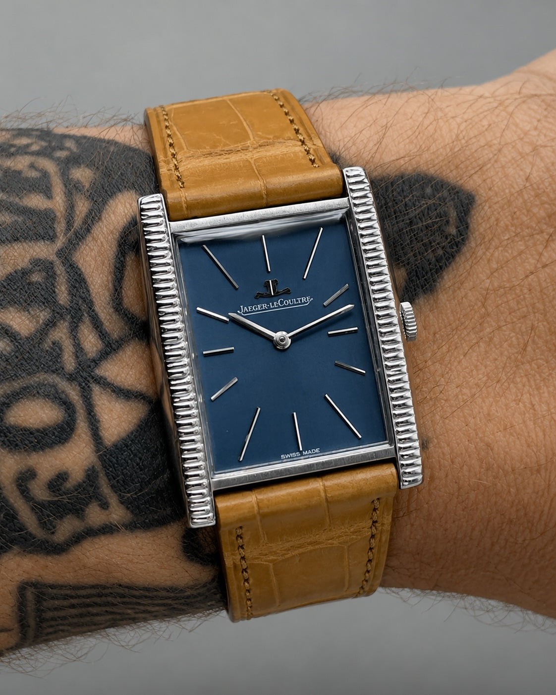 A blue dial tank watch on a leather strap