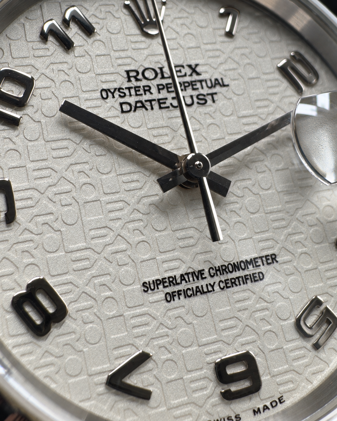 Close-up of the Rolex Datejust 16220 white Jubilee computer dial, hands and raised Arabic numerals.