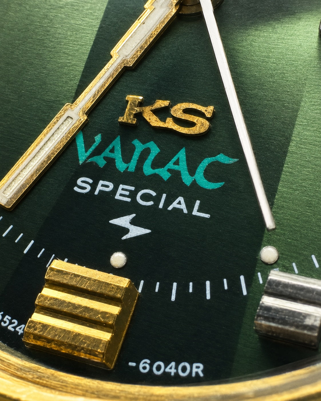 Close-up of a Vanac Special watch dial with a textured dark green background, gold-tone hands and markers, turquoise 'VANAC' lettering, and white 'SPECIAL' text.