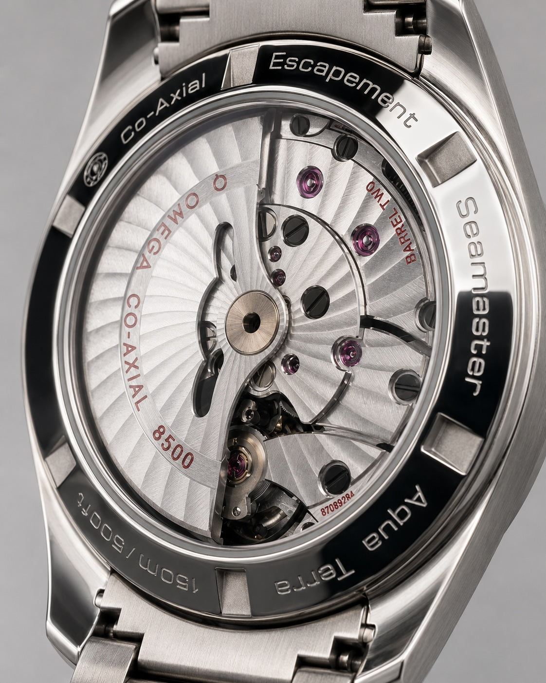 Close-up of the back case of an Omega Seamaster Co-Axial Aqua Terra watch, showing the exposed silver mechanical movement with visible screws and internal details.