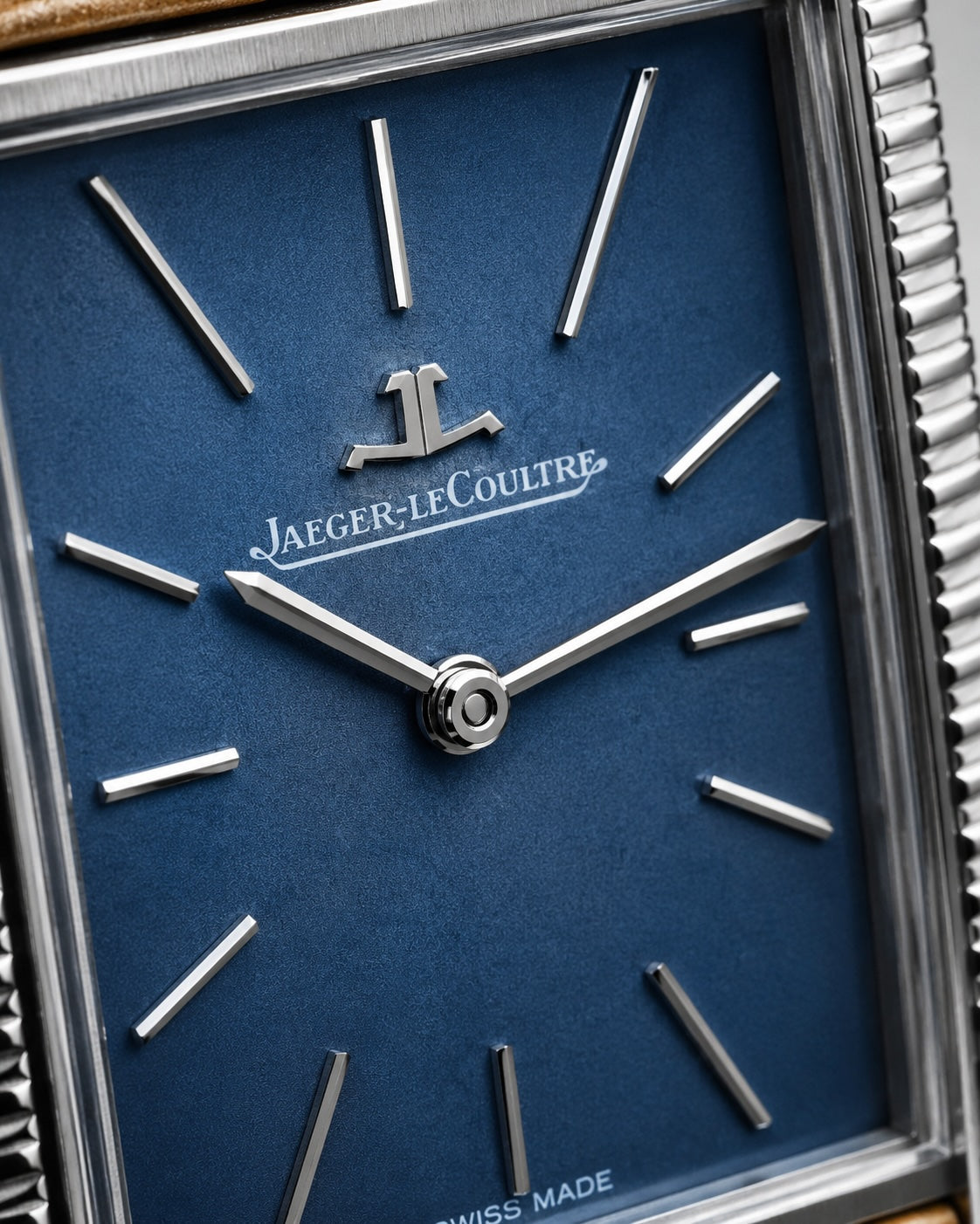 Close-up of a Jaeger-LeCoultre watch face with a deep blue dial, silver baton hour markers, and a silver-toned case.