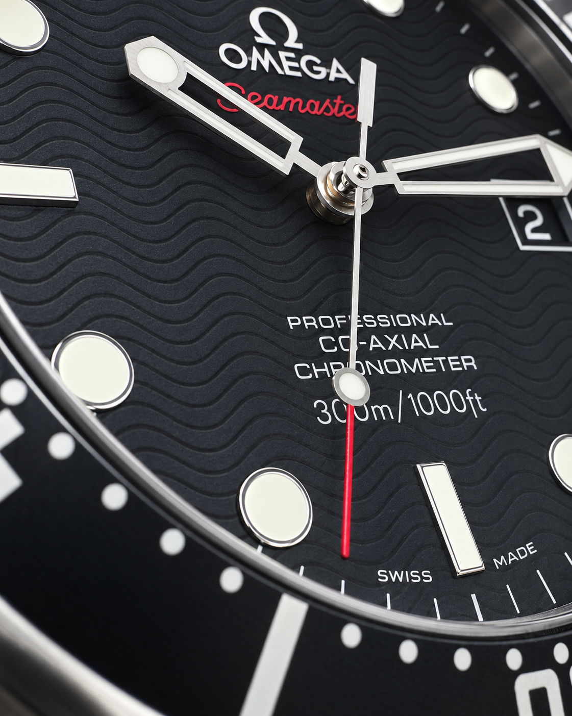 Close-up of an Omega Seamaster Professional Co-Axial Chronometer watch dial, showing a textured black face with silver-tone hands, luminous markers, white text, and a thin red seconds hand.