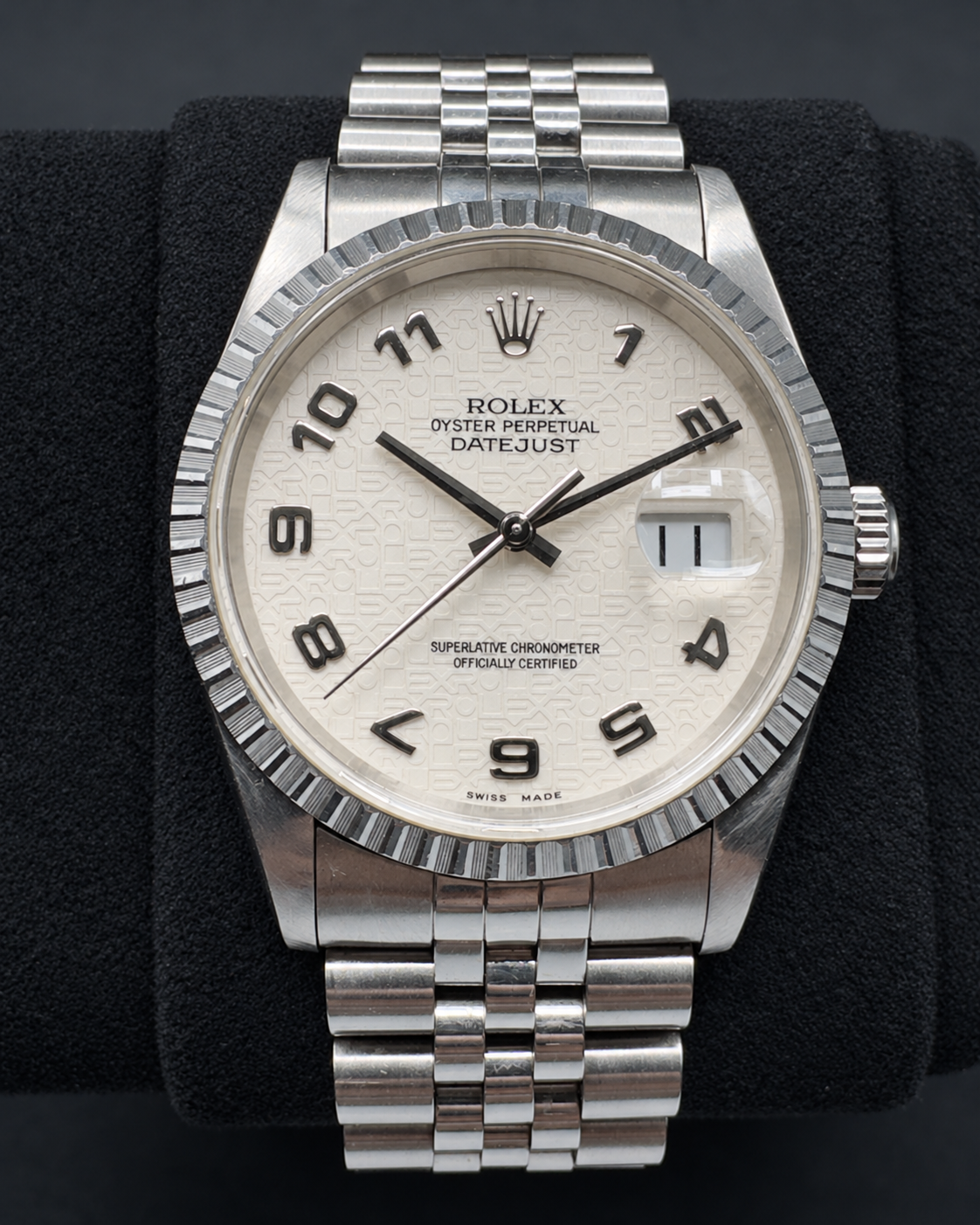 Rolex Datejust 16220 with white Jubilee computer dial, engine-turned bezel and Jubilee bracelet on a black cushion.