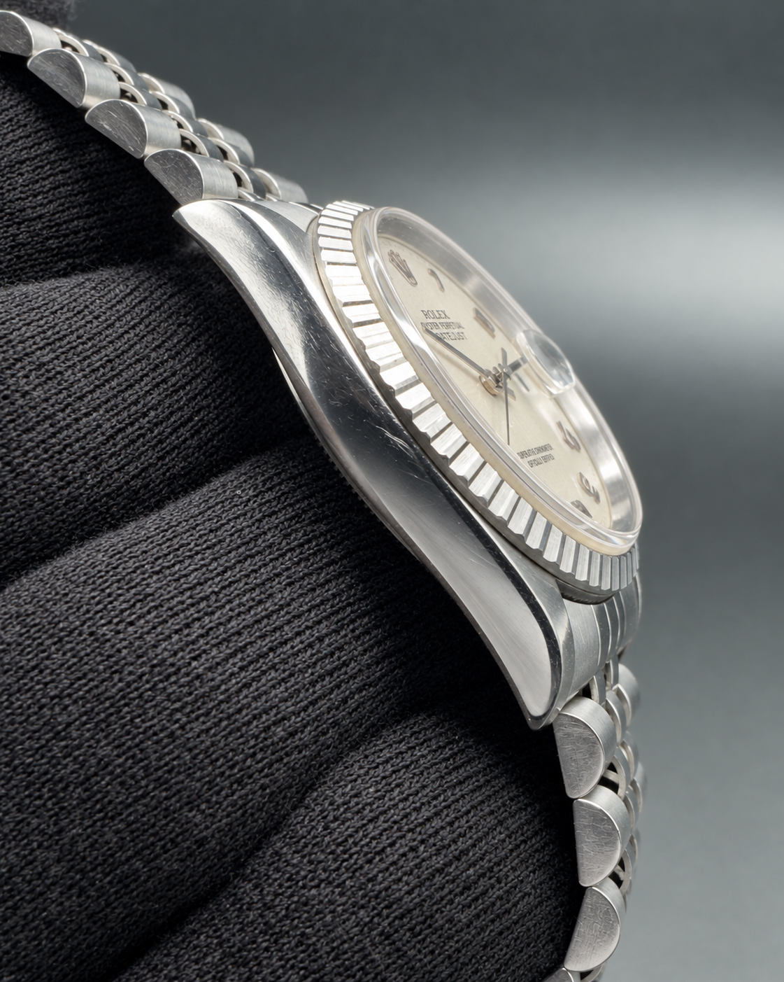 Angled side view of the Rolex Datejust 16220 case, crystal, engine-turned bezel and bracelet.