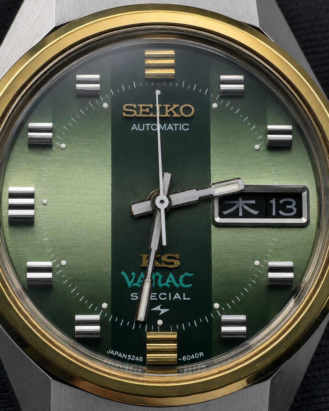 Close-up of a Seiko Vamac Special automatic watch with a green striped dial, gold-tone bezel, and silver-tone case.
